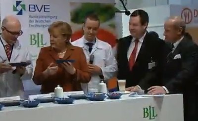 Ангела Меркель на аграрной выставке в Берлине. Телекадр Deutsche Welle